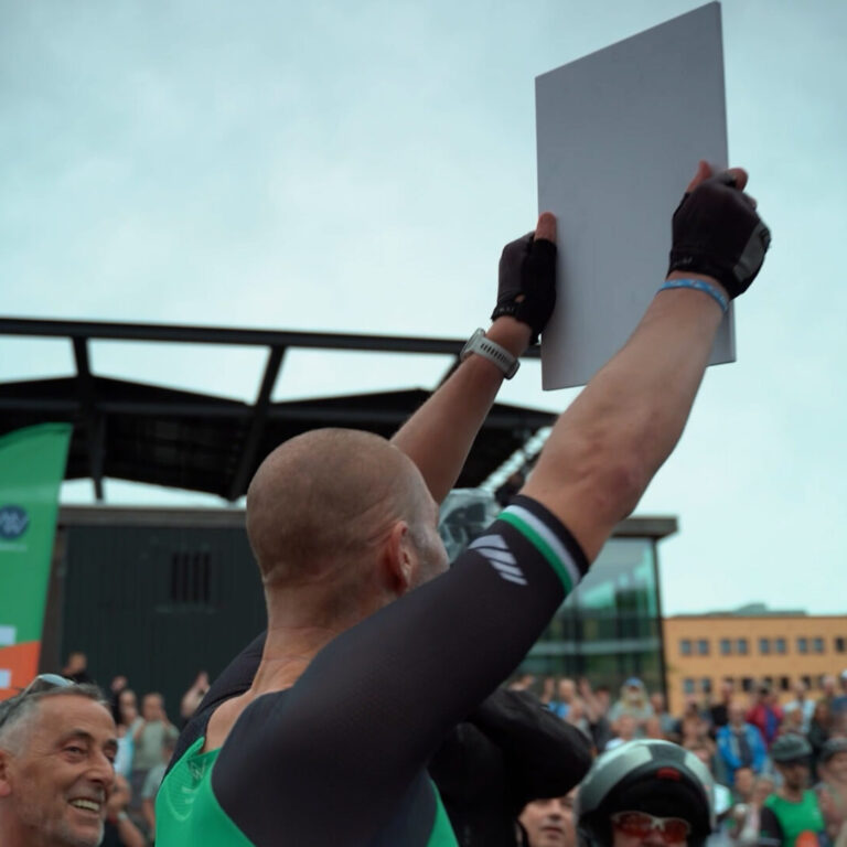 Maarten van der Weijden met een cheque boven zijn hoofd tijdens de Elfstedentriatlon 2023.
